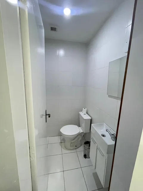 Banheiro claro com barras de apoio